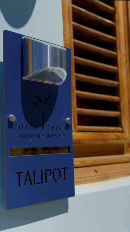 Accroche-porte bleue du Talipot aux Forty Palms Lamentin Guadeloupe avec fenêtre à jalousies en bois