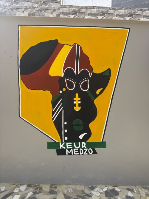 Fresque Keur Medzo au lodge Lac Rose à Niaga, Sénégal, présentant des masques africains colorés sur fond jaune