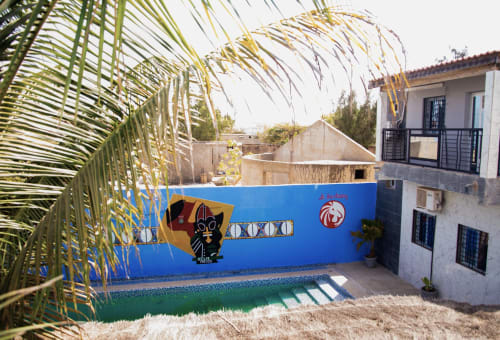 Cour de l'hôtel Keur Medzo à Lac Rose avec murs peints en bleu, palmiers et architecture traditionnelle à Niaga, Sénégal