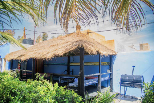 Bungalow à toit de chaume à l'hôtel Keur Medzo sur le Lac Rose, Niaga Sénégal avec murs bleus et palmiers
