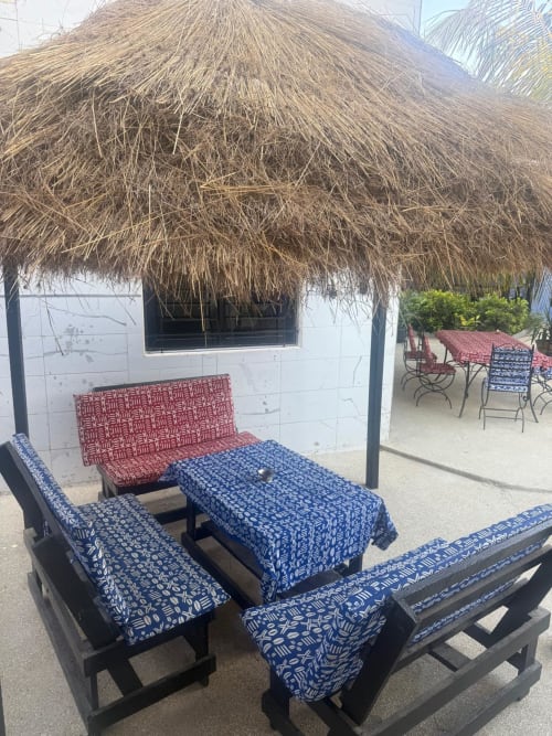 Salon palapas en bord de plage à Keur Medzo Lac Rose avec coussins bleus à motifs et toit en chaume