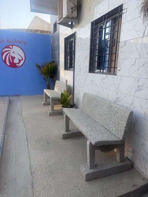 Espace de détente en cour chez Keur Medzo à Lac Rose, Niaga avec bancs en pierre et plantes en pots