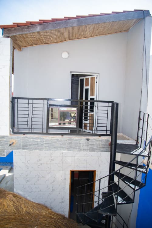 Chambre moderne à Keur Medzo Lac Rose avec balcon, garde-corps métallique et façade carrelée blanche à Niaga, Sénégal