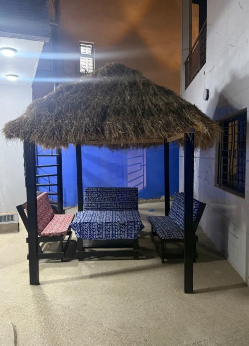 Intérieur de case traditionnelle avec toit de chaume à Keur Medzo, hôtel Lac Rose, aux murs bleus et mobilier aux motifs colorés