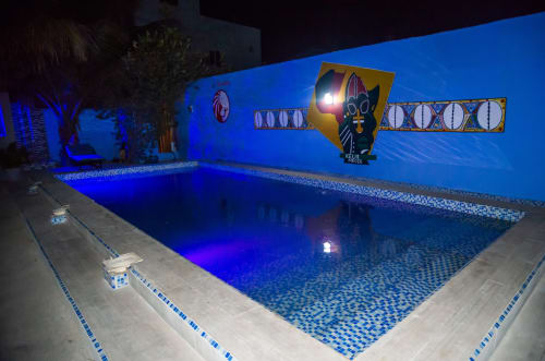 Piscine illuminée de l'hôtel Keur Medzo Lac Rose à Niaga avec murs bleus et installations artistiques décoratives