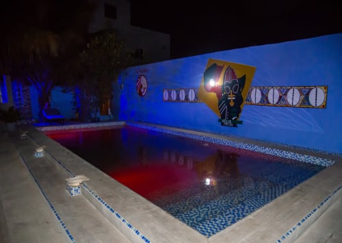 Piscine illuminée du Keur Medzo Lac Rose aux murs bleus, eaux rouges et art décoratif sénégalais la nuit