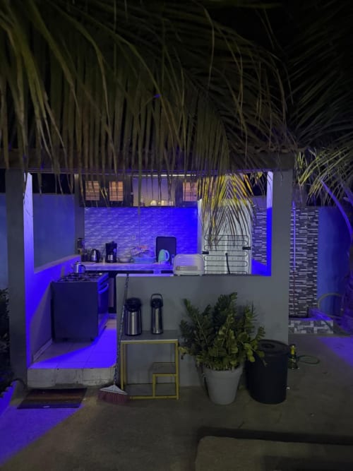 Cuisine moderne à Keur Medzo Lac Rose avec éclairage ambiant bleu, palmes au-dessus et plantes en pot à Niaga