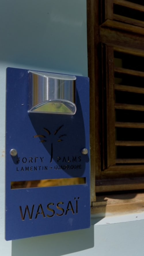 Panneau Forty Palms à l'entrée de Lamentin, Guadeloupe - logo de palmier stylisé sur plaque bleue