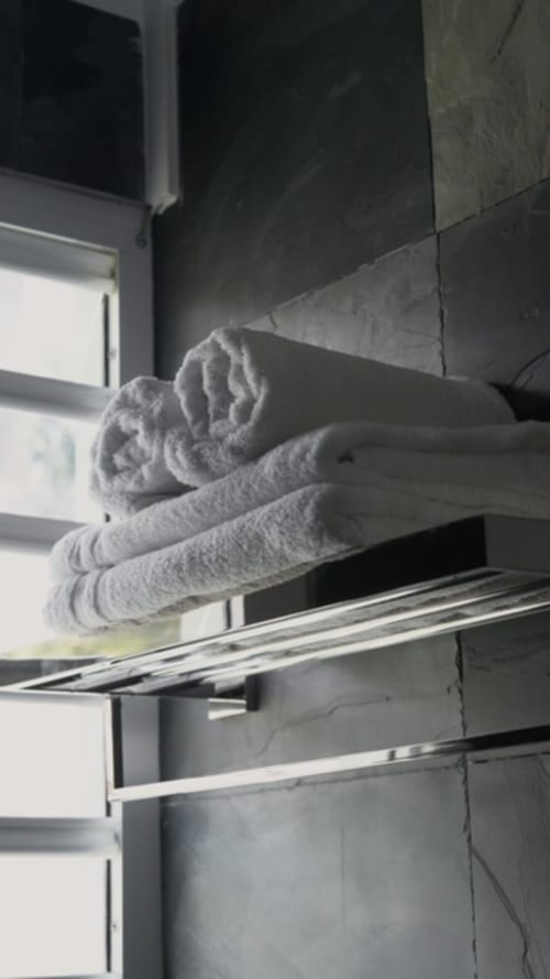 Serviettes roulées sur étagère métallique dans la salle de bains du gîte FORTY PALMS, Lamentin Guadeloupe