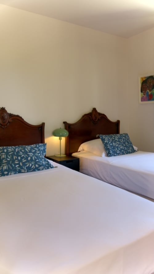 Lits jumeaux avec oreillers à motifs bleus au gîte Forty Palms à Lamentin, Guadeloupe