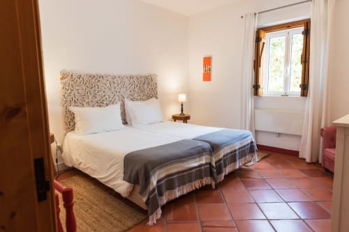 Quarto espaçoso da vila Casas de Juromenha em Juromenha com camas de solteiro, cabeceira estampada, piso de terracota e jardim