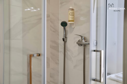 Moderno box de chuveiro no hotel Misericórdia Rooms em Guarda com chuveiro tipo rainfall e produtos de higiene premium