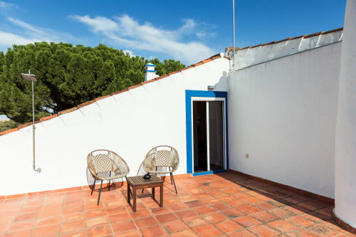Terraço na cobertura da vila Casas de Juromenha em Portugal com área de estar, porta azul e vistas para a zona rural