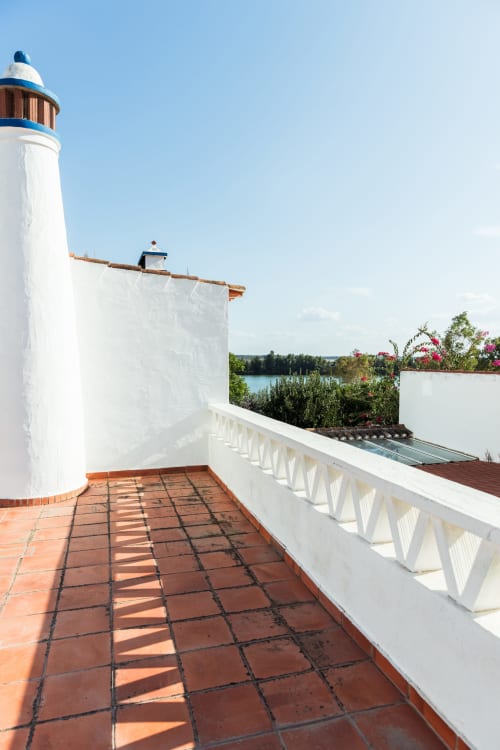 Terraço do farol da villa Casas de Juromenha com vistas para o rio, corrimão branco e jardim florido em Juromenha