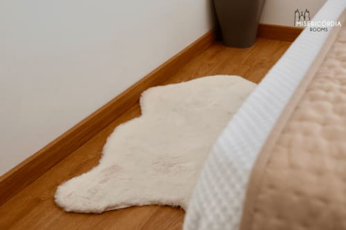 Detalhe aconchegante do quarto da SM Stays Collection, Torre de Menagem em Guarda com piso de madeira e tapete branco de pele de ovelha