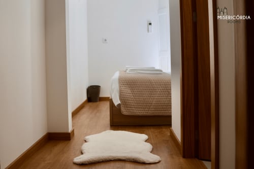 Quarto moderno na Torre de Menagem do SM Stays Collection, Guarda, com pisos de madeira, cama e decoração minimalista