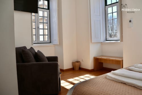 Quarto Sé Catedral luminoso na SM Stays Collection em Guarda com poltrona preta, secretária de madeira e cama com vista para a cidade