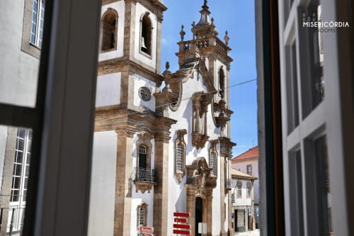 Catedral histórica branca e de pedra com torre ornamentada vista do quarto Sé Catedral na SM Stays Collection em Guarda, Portugal