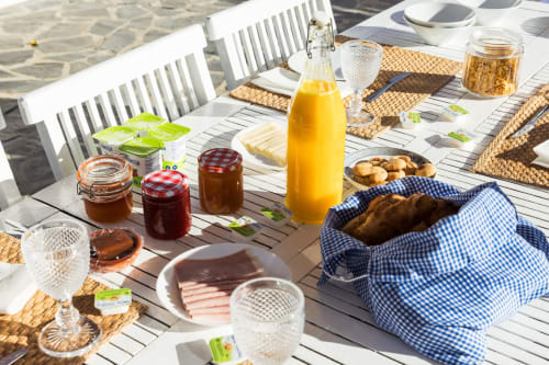 Mesa de café da manhã ao ar livre na villa Casas de Juromenha com pastéis frescos, suco de laranja, geleias e pãezinhos