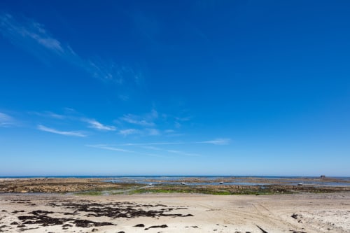 Vue côtière avec bassins de marée et ciel bleu près de La Maison 1903 à Trévou-Tréguignec