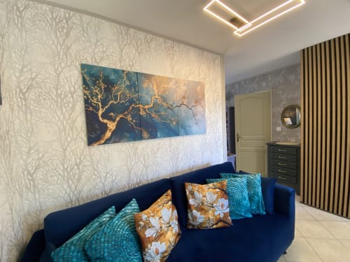 Suite chambre élégante à Ô Clair De Lune à Sarlat : canapé bleu marine, œuvres d'art dorées et papier peint raffiné