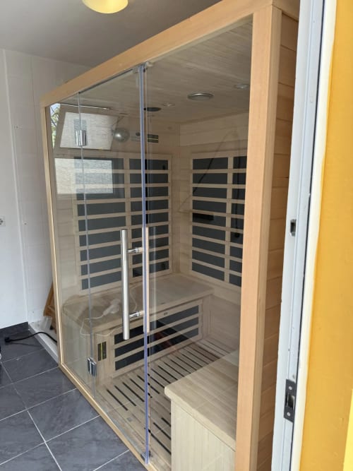 Modern infrared sauna with glass doors and wooden interior at Golden Mermaid Villa Portugal
