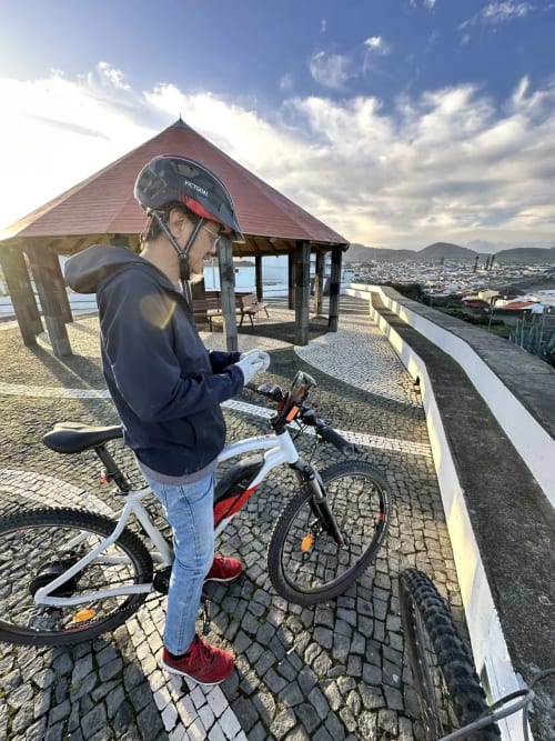 Cyclist with helmet at Golden Mermaid Villa viewpoint overlooking Portuguese coastline and bay