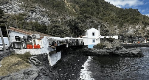 Golden Mermaid Villa beachfront property with white buildings, dining area, and rocky coastline in Portugal