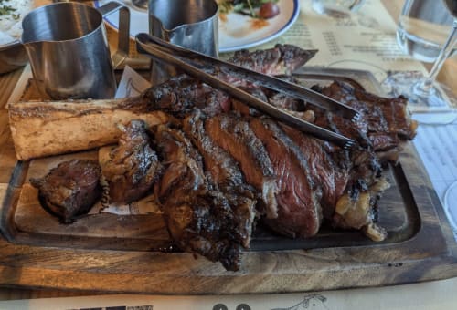 Grilled meat platter at Golden Mermaid Villa, sliced steak with herbs on wooden board