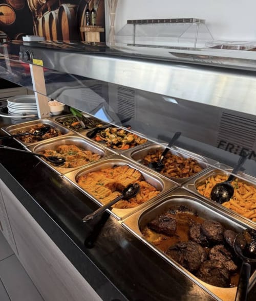 Golden Mermaid Villa buffet display with multiple hot food dishes in metal containers under heated glass service counter