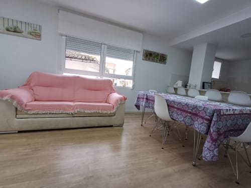 Bright living area in Algemesí Home apartment with pink sofa, dining table with purple tablecloth, and city views from