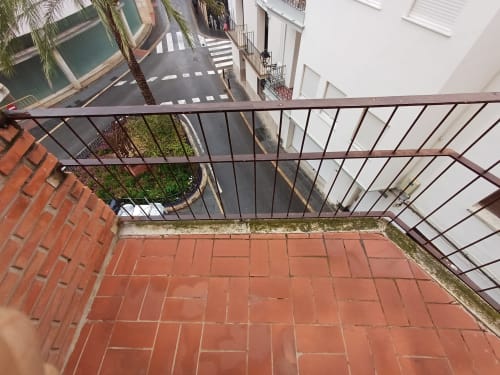 Balcony view from Algemesi Home apartment overlooking city street with crosswalk and white buildings