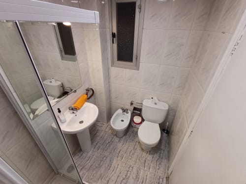 Salle de bain moderne avec lavabo, bidet et toilettes dans l'appartement Algemesi Home, carrelage et miroir