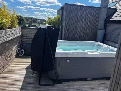 Bain à remous sur le toit avec eau turquoise à l'hôtel Hébergements C&C à Angres, France, par beau temps