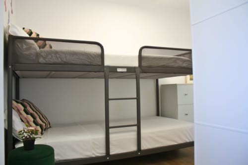 Dos literas de metal con ropa de cama blanca en una habitación estilo dormitorio del apartamento Love Rent4 Málaga en Torremolinos