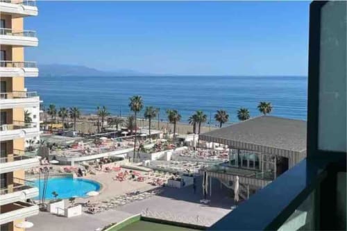 Apartamento frente al mar en Torremolinos con piscina, palmeras y vistas al Mediterráneo sobre la playa de Bajondillo