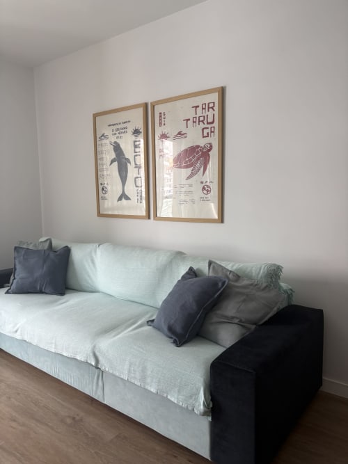 Salón moderno con sofá claro, estampados decorativos de vida marina y vistas al océano en apartamento de Torremolinos
