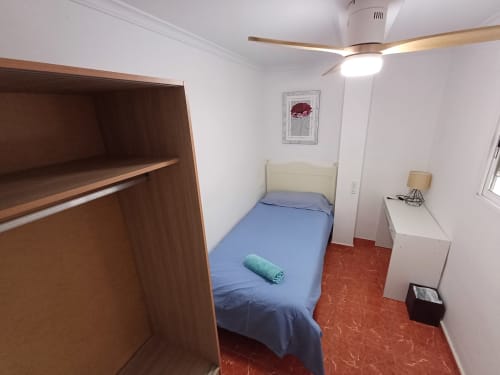 Chambre compacte à Algemesi Home avec lit simple, armoire en bois et carrelage rouge à Algemesí, Espagne