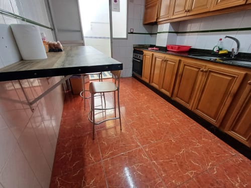 Cuisine avec armoires en bois, table à manger et carrelage rouge à l'appartement Algemesi Home, Espagne
