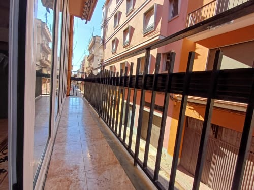 Estret balcó cobert amb barana negra a l'apartament Algemesi Home a Algemesi, Espanya, amb vistes als edificis de la ciutat