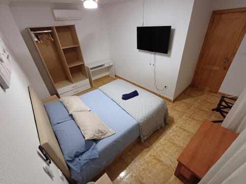 Habitació espaciosa en apartament d'Algemesí amb llits bessons, TV, armari i sòl de fusta