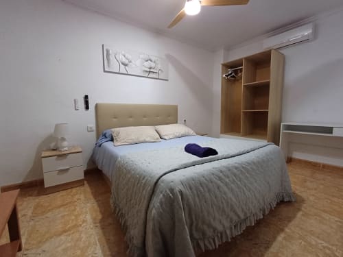 Dormitorio moderno en apartamento de Algemesi con cama queen, muebles de madera, suelos de parqué y aire acondicionado