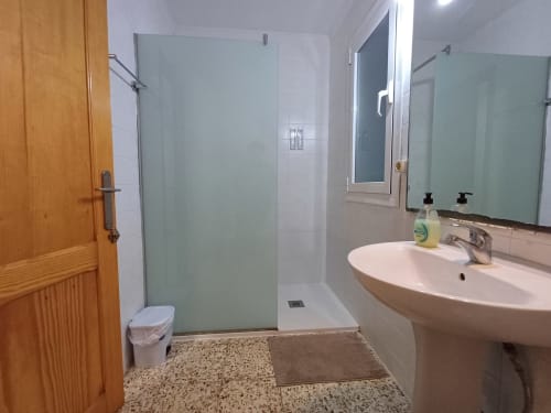 Bany modern amb dutxa gran, lavabo rodó i tocador amb mirall a l'apartament Algemesi Home a Algemesí, Espanya