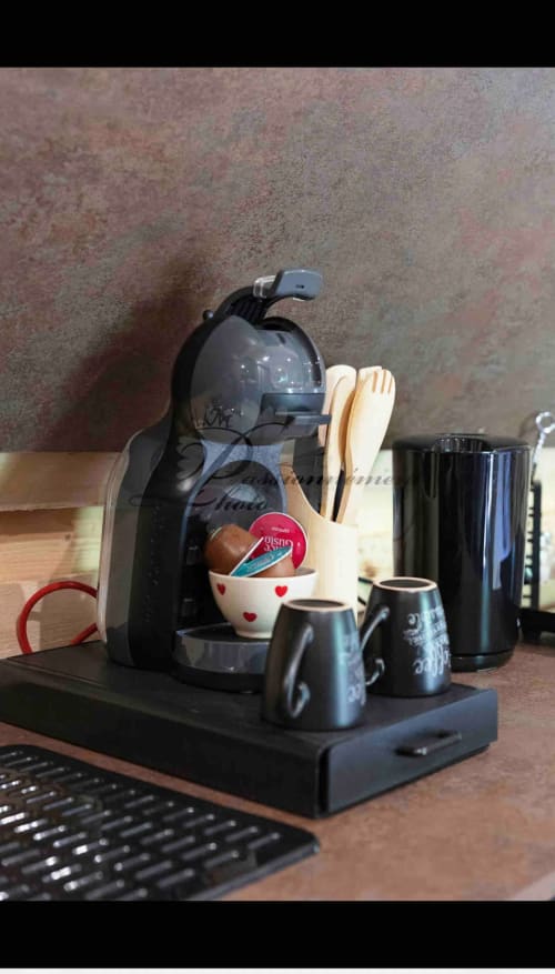 Espresso coffee maker with cups and accessories on desk at Les Cabanes des Marchous cottage rental