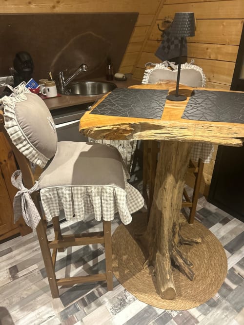Rustic wooden table with checkered chair at Les Cabanes des Marchous cottage in Granges-Aumontzey, France