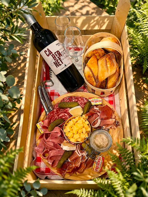 Gourmet-Picknickkorb in den Lodges de Vaugrigneuse mit Wein, Charcuterie, Brot und Käse im Garten