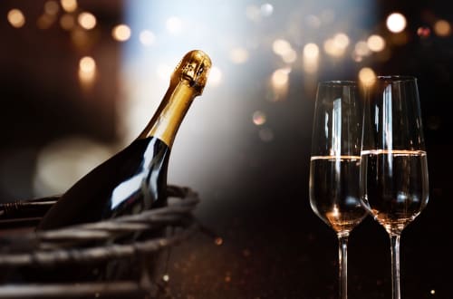 Bouteille de champagne et verres remplis avec lumières bokeh, ambiance festive à l'hôtel Hébergements C&C à Angres