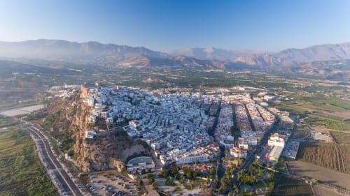 Vista aérea del pueblo blanco de Salobreña en una colina rocosa con la fortaleza Alcazaba, rodeado de montañas