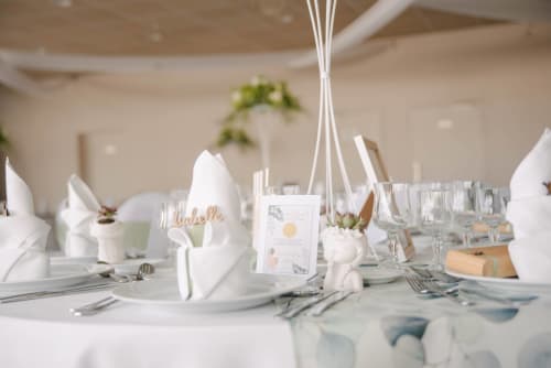 Elegant banquet table setting at Le Domaine De La Marnière, Villainville with white napkins, place cards, and glassware