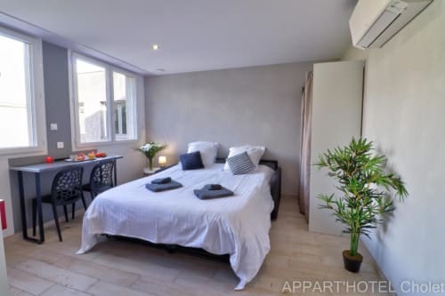Studio moderne à l'Appart'Hôtel Cholet avec lit king-size, espace de travail, kitchenette et vue sur jardin